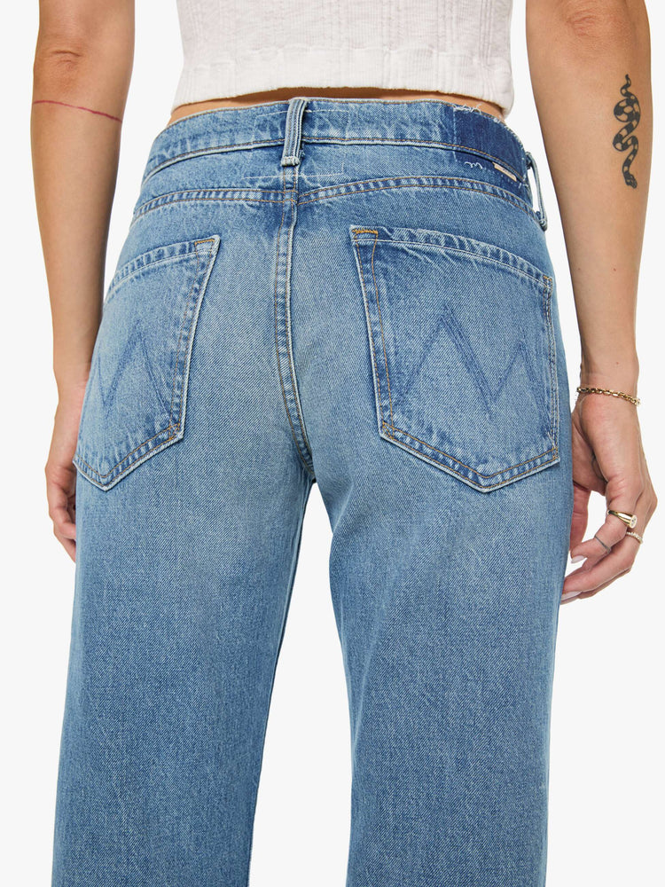 Back view of a woman in a  straight leg with a bit of a kick, the jean features a mid rise, full-length inseam and clean hem in med blue wash.