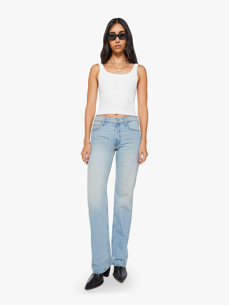 Front view of a woman in a light blue straight leg with a bit of a kick, the jean features a mid rise, full-length inseam, distressed hem and relaxed fit.