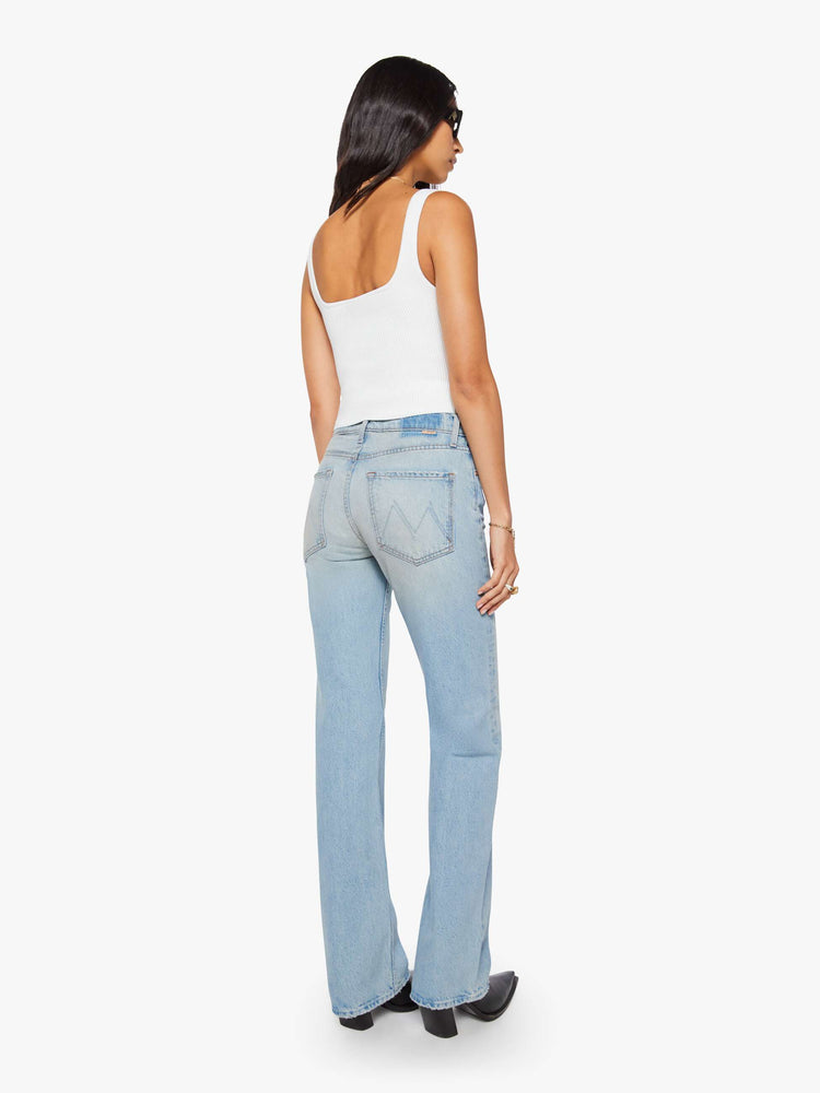 Back view of a woman in a light blue straight leg with a bit of a kick, the jean features a mid rise, full-length inseam, distressed hem and relaxed fit.