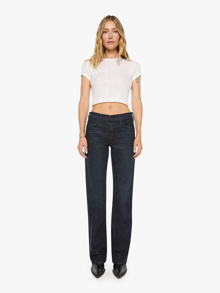 Front view of a woman in black straight leg with a bit of a kick, the jean features a mid rise, full-length inseam, distressed hem and relaxed fit.