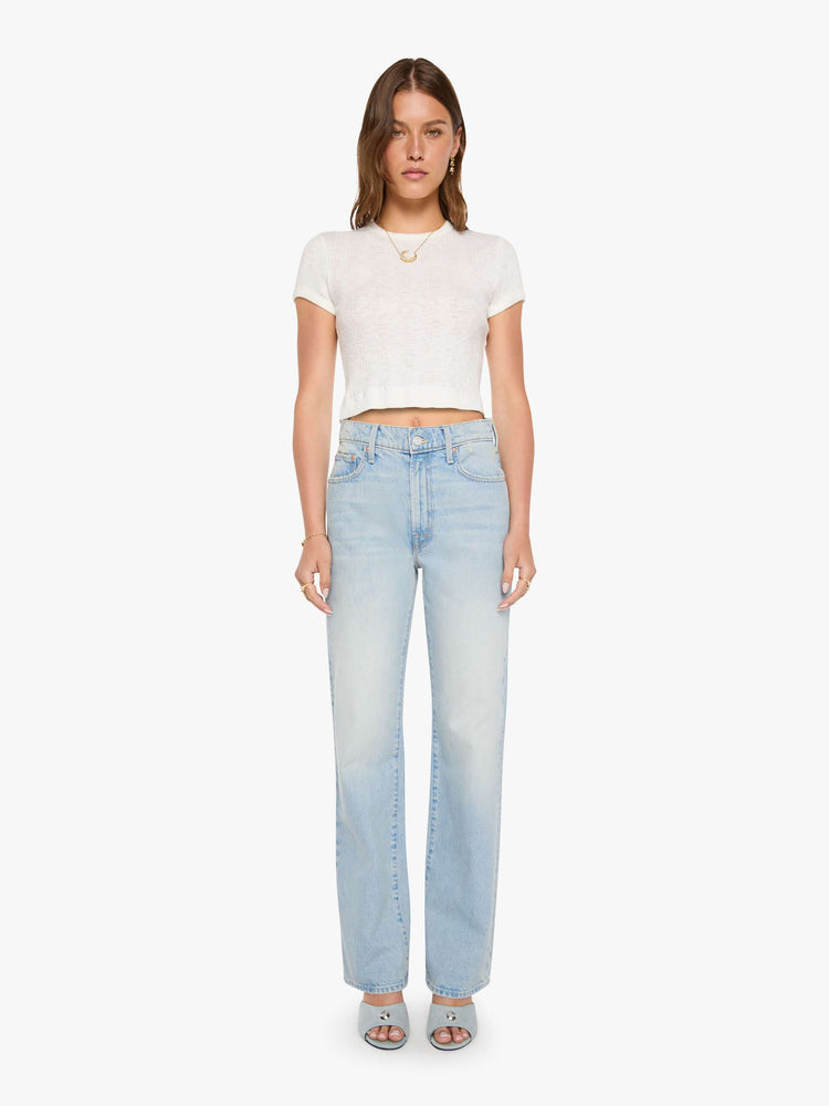 Front view of a woman in a light blue high-rise jeans with a wide straight leg, zip fly and long 31-inch inseam with a clean hem. 