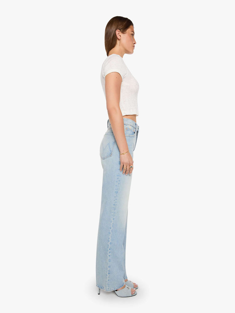Side view of a woman in a light blue high-rise jeans with a wide straight leg, zip fly and long 31-inch inseam with a clean hem. 