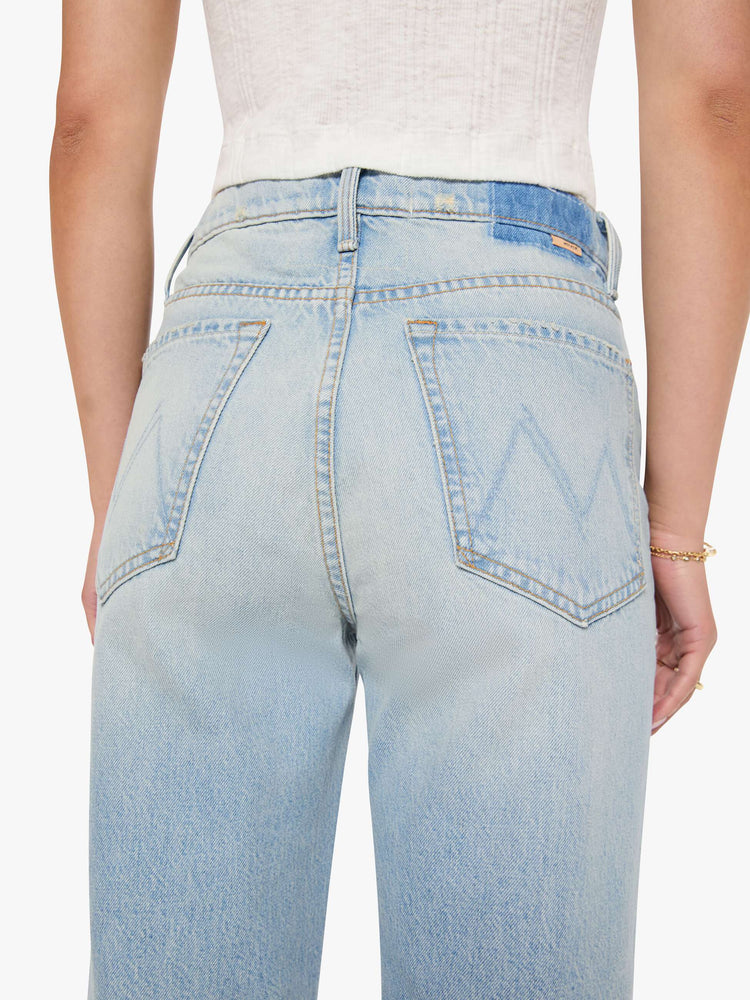Back close up view of a woman in a light blue high-rise jeans with a wide straight leg, zip fly and long 31-inch inseam with a clean hem. 