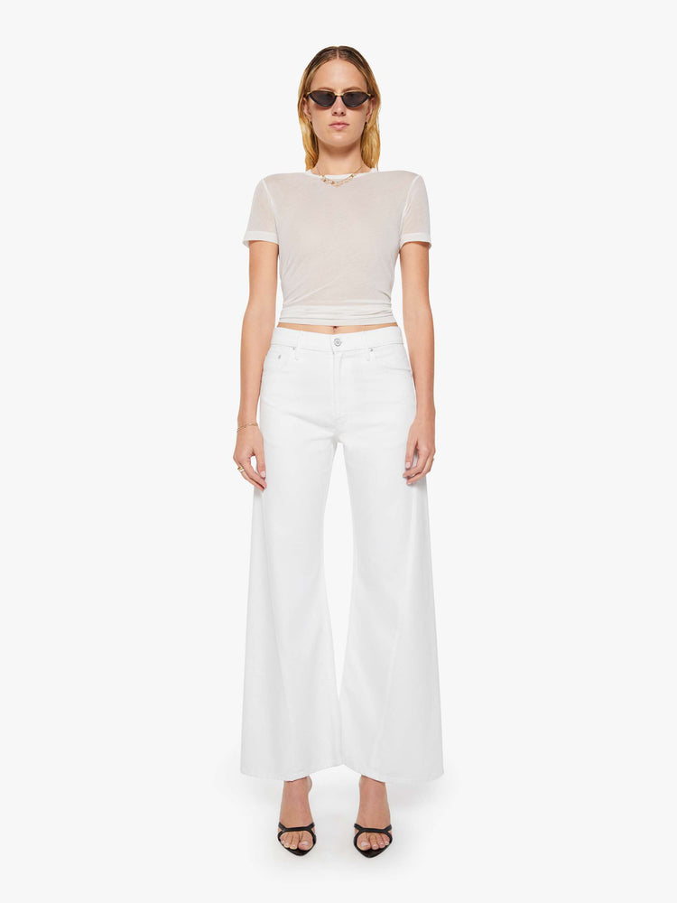 Front view of a woman in a white high-rise pants have a zip fly, loose wide leg with a curved outer seam and a 32-inch inseam with a clean hem.