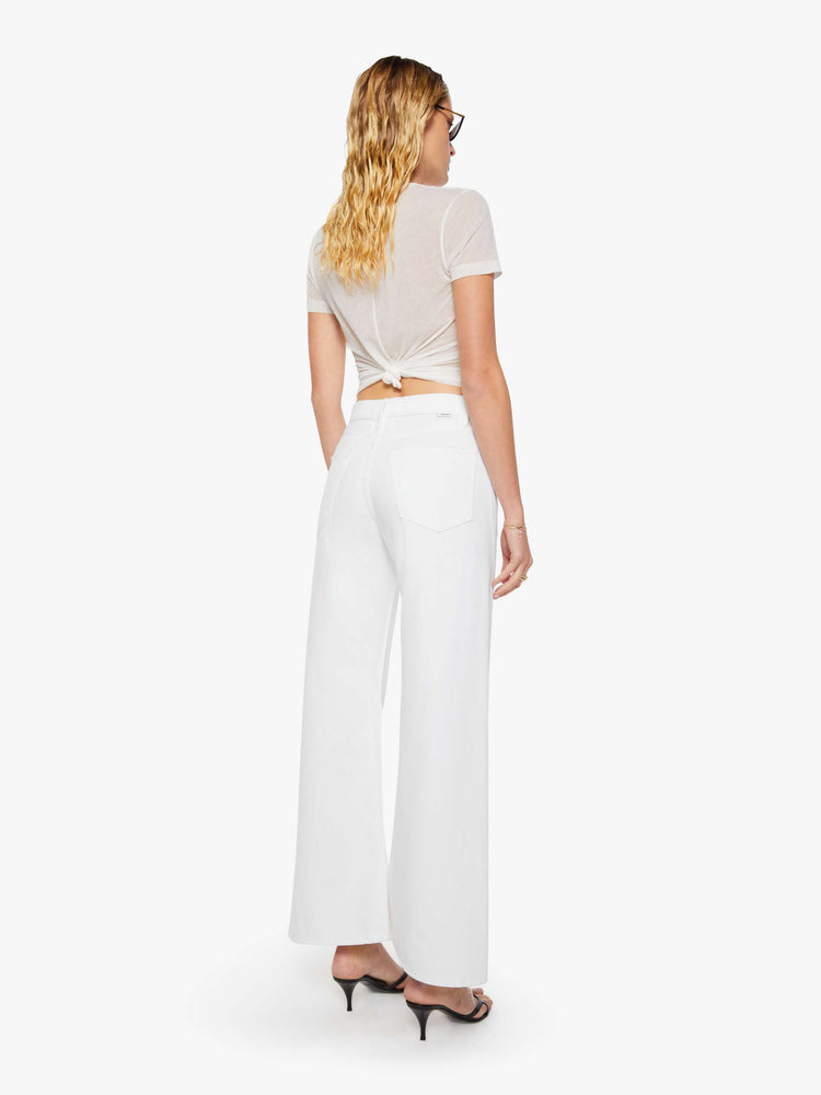 Back view of a woman in a white high-rise pants have a zip fly, loose wide leg with a curved outer seam and a 32-inch inseam with a clean hem.