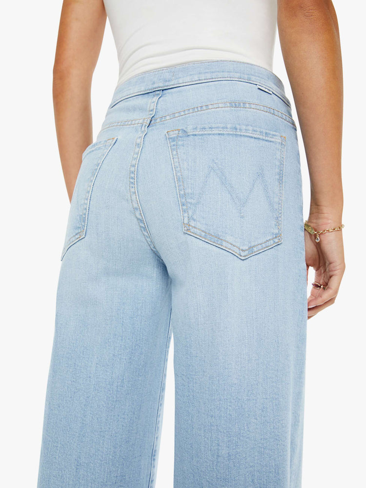 Swatch view of a woman in a light blue high rise wide leg jean, zip fly, tabbed waistband, long 31-inch inseam and a clean hem.