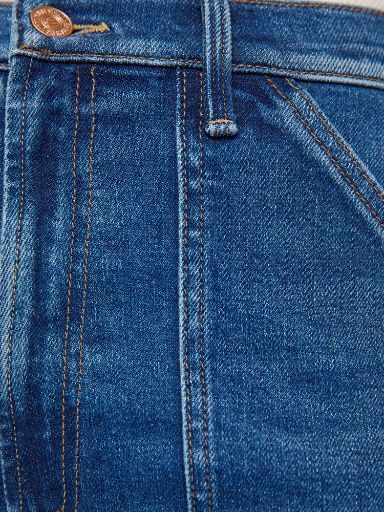 Swatch view of a woman in med blue super high-rise jeans with a loose fit, wide leg, patch pockets, zip fly and 34-inch inseam with a clean hem.