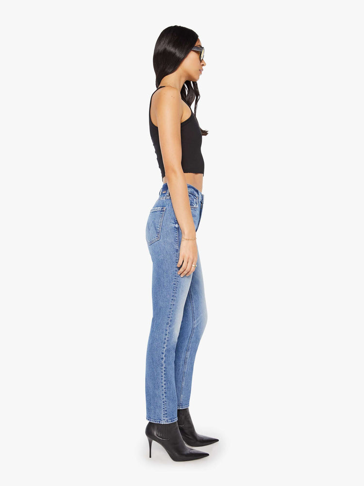 Side view of a woman in a light blue high-rise straight-leg jeans with a 28.25-inch inseam and a clean hem.