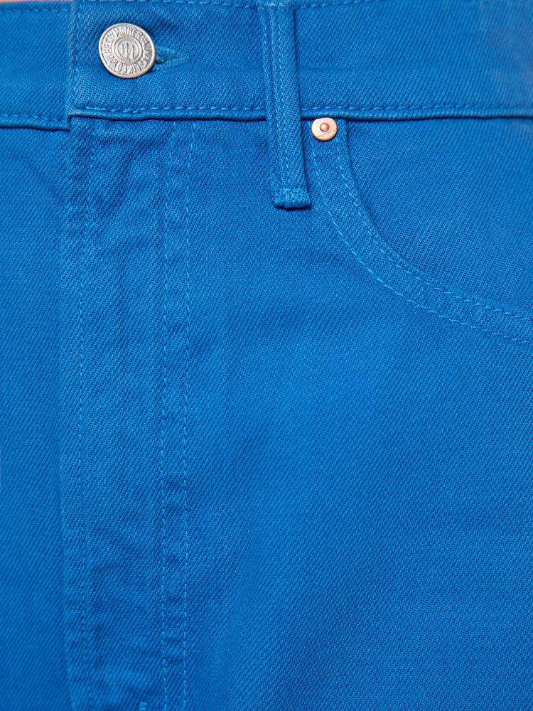 Swatch view of a woman in a bright blue super high-waisted pant with a zip fly, wide, curved leg and an ankle-length inseam with a cuffed, frayed hem.
