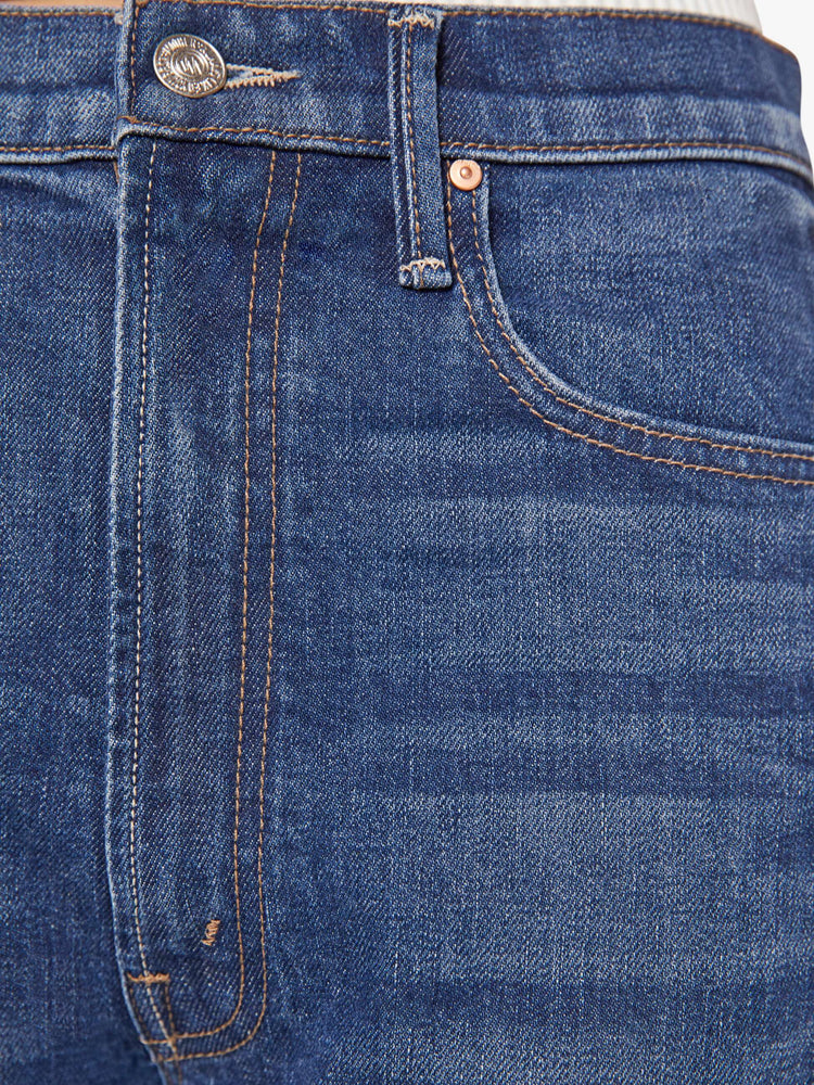 Swatch view of a woman in a dark blue super high-waisted barrel jean with a zip fly, wide, curved leg and an ankle-length inseam with a cuffed, frayed hem.