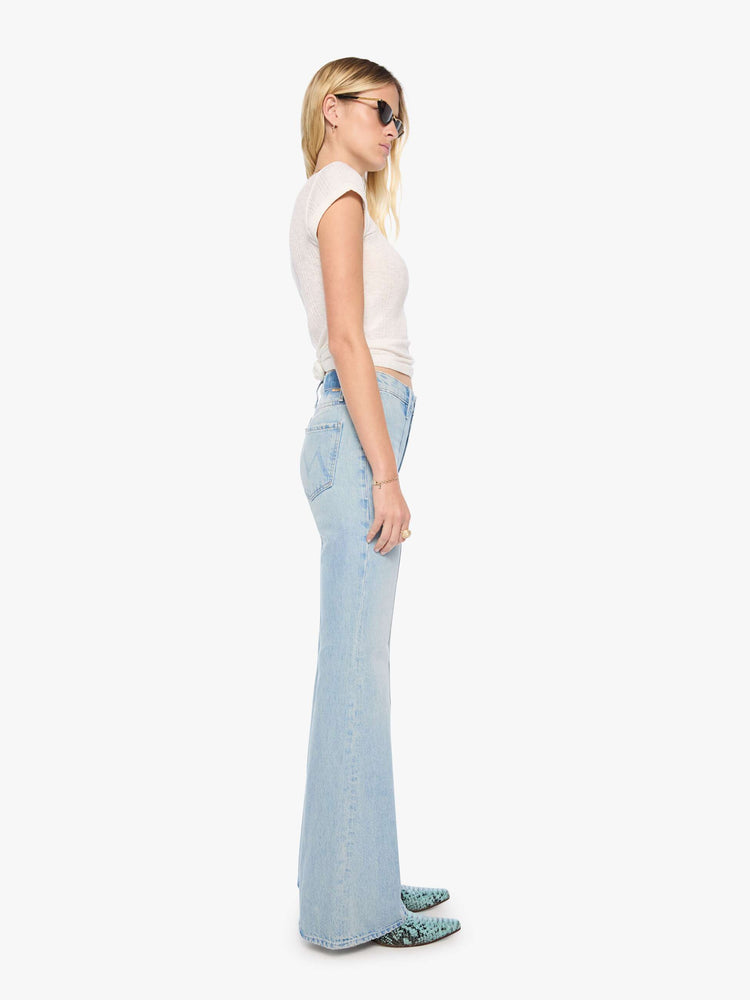 Side view of a woman in a high-rise flare jean with a zip fly, seamed details down the front, a long 34-inch inseam and a clean hem.