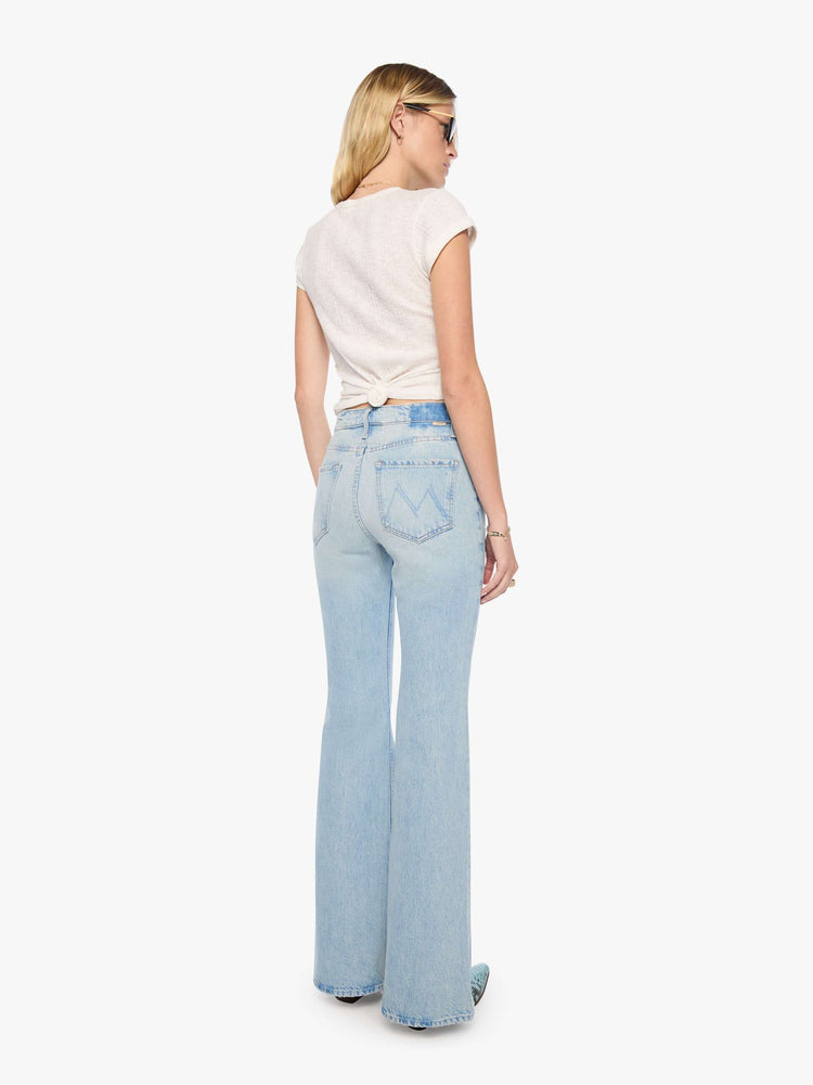 Back view of a woman in a high-rise flare jean with a zip fly, seamed details down the front, a long 34-inch inseam and a clean hem.