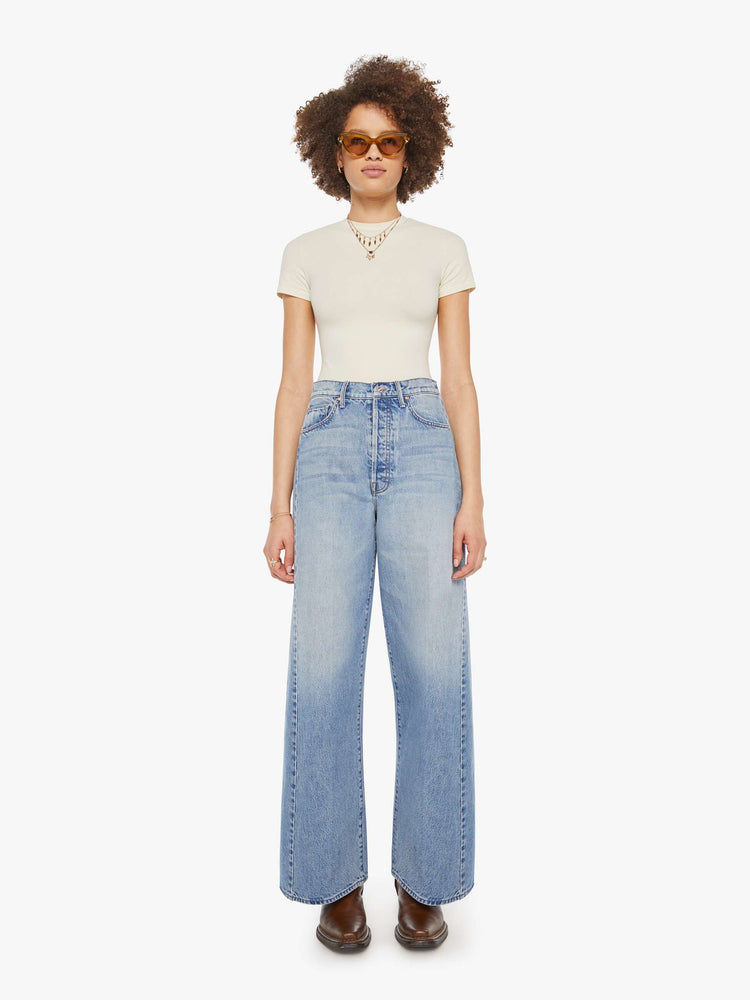 Front view of a woman in a light blue super high-waisted barrel-leg jeans with a long 31-inch inseam, button fly, clean hem and relaxed fit.