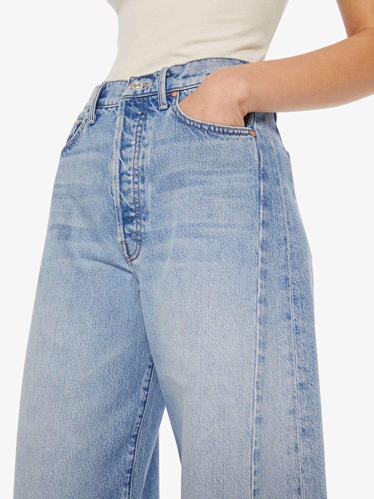 Close up view of a woman in a light blue super high-waisted barrel-leg jeans with a long 31-inch inseam, button fly, clean hem and relaxed fit.