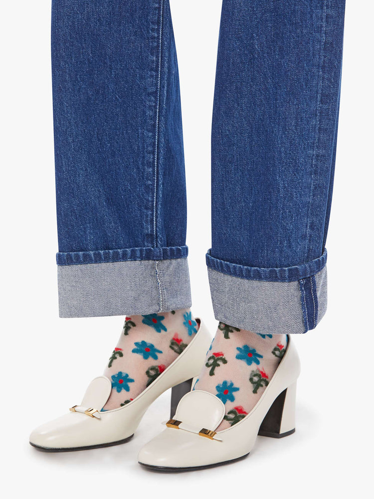 Hem view of a woman in a mid blue straight-leg jeans with a high rise, zip fly and 29-inch inseam with a cuffed hem.