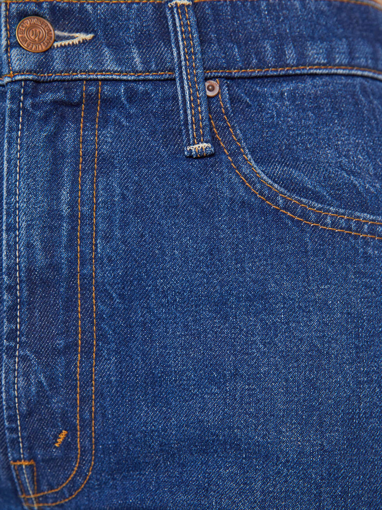 Swatch view of a woman in a mid blue straight-leg jeans with a high rise, zip fly and 29-inch inseam with a cuffed hem.