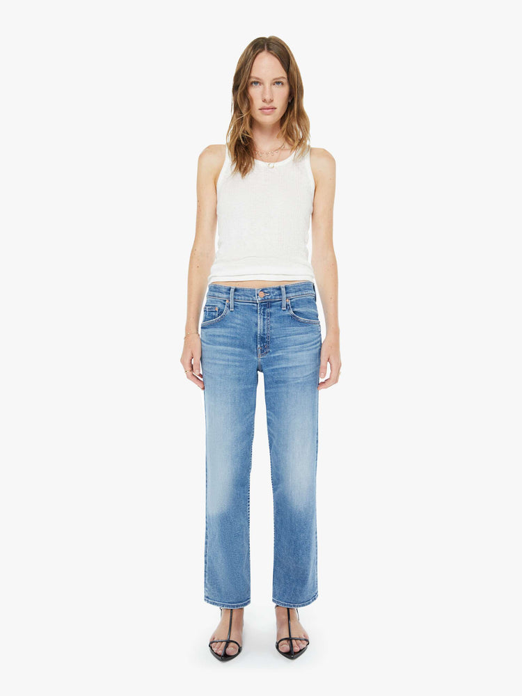 Front view of a woman in a light blue high-rise straight-leg jeans with a zip fly, ankle-length inseam and a clean hem.