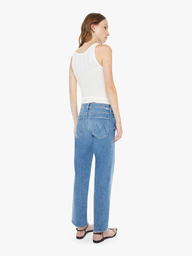 Back view of a woman in a light blue high-rise straight-leg jeans with a zip fly, ankle-length inseam and a clean hem.
