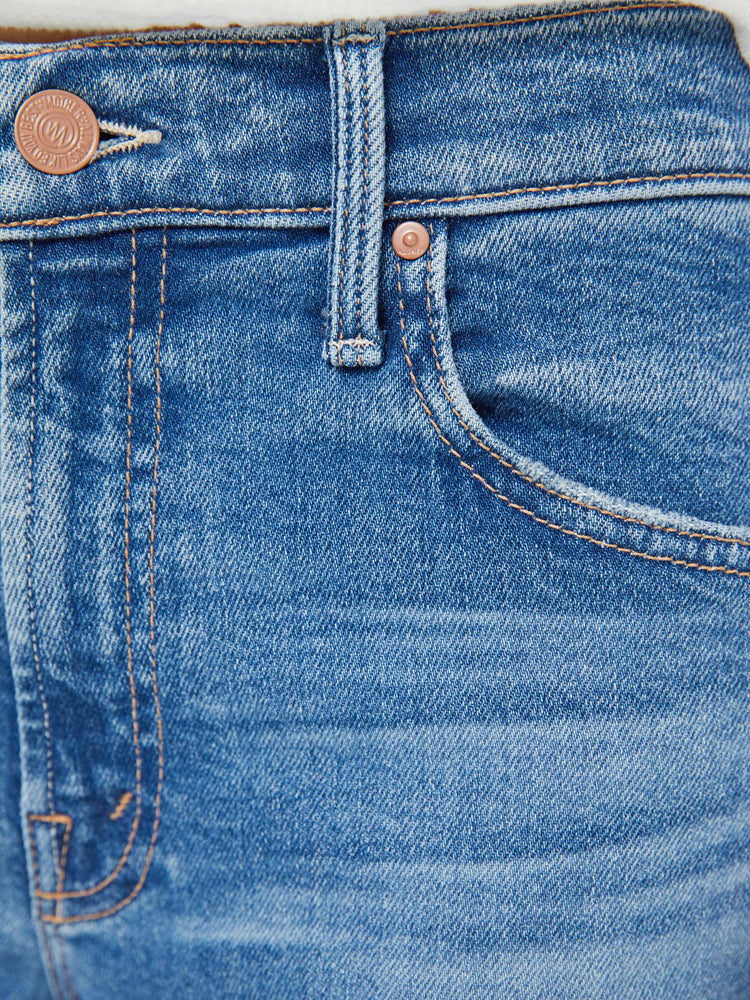 Swatch view of a woman in a light blue high-rise straight-leg jeans with a zip fly, ankle-length inseam and a clean hem.