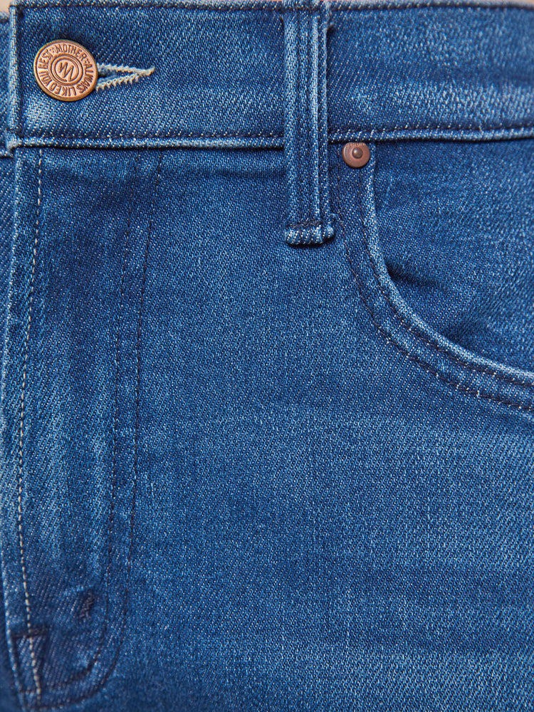 Swatch view of a woman in a mid blue high-rise jeans with a straight leg, zip fly and an ankle-length inseam with a clean hem.