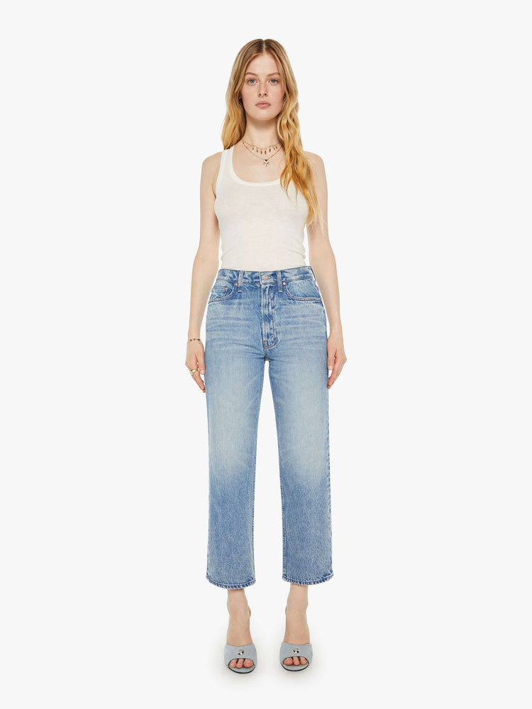 Front view of a woman in a light blue high-rise jeans with a straight leg, zip fly and an ankle-length inseam with a clean hem.