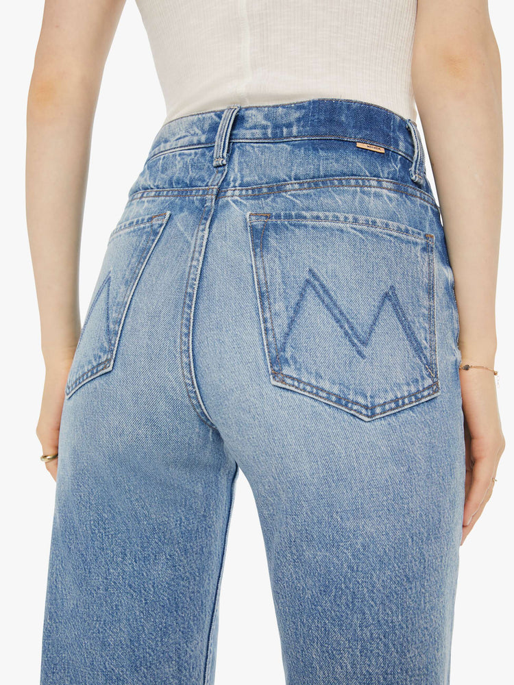 Back close up view of a woman in a light blue high-rise jeans with a straight leg, zip fly and an ankle-length inseam with a clean hem.