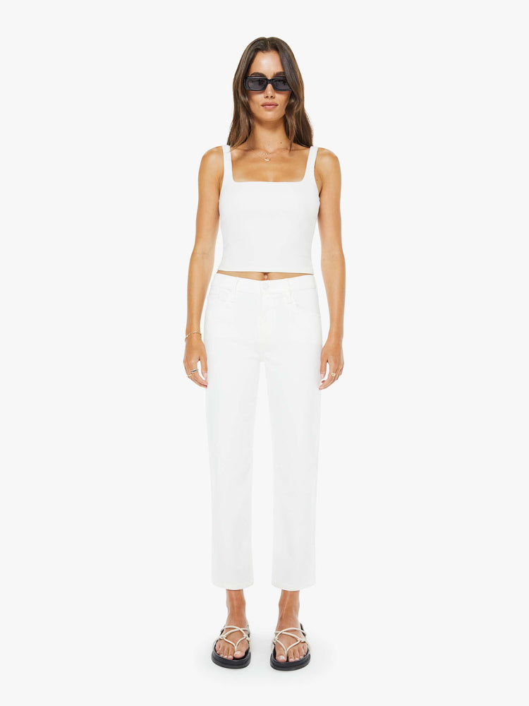 Front view of a woman in a white high-rise jeans with a straight leg, zip fly and an ankle-length inseam with a clean hem. 