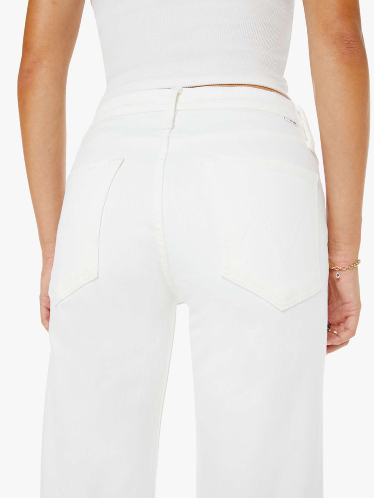 Back view of a woman in a white high-rise jeans with a straight leg, zip fly and an ankle-length inseam with a clean hem. 