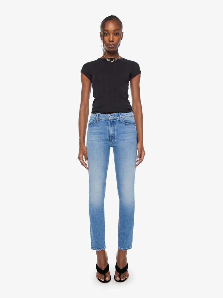 Front view of a woman in mid blue mid-rise jean has a straight leg, zip fly, 29-inch inseam and a clean hem. 
