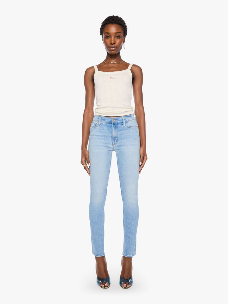 Front view of a woman in light blue mid-rise jean has a straight leg, zip fly, 29-inch inseam and a clean hem.