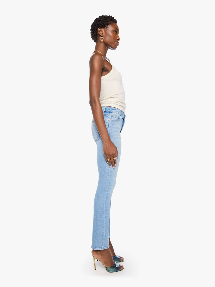 Side view of a woman in light blue mid-rise jean has a straight leg, zip fly, 29-inch inseam and a clean hem.