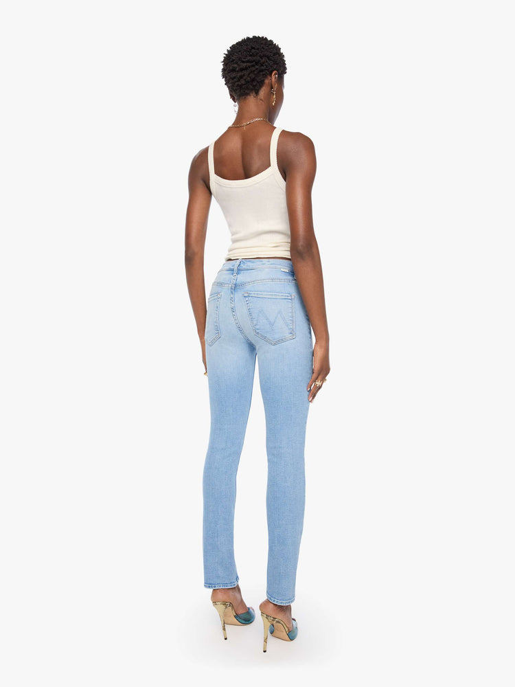 Back view of a woman in light blue mid-rise jean has a straight leg, zip fly, 29-inch inseam and a clean hem.