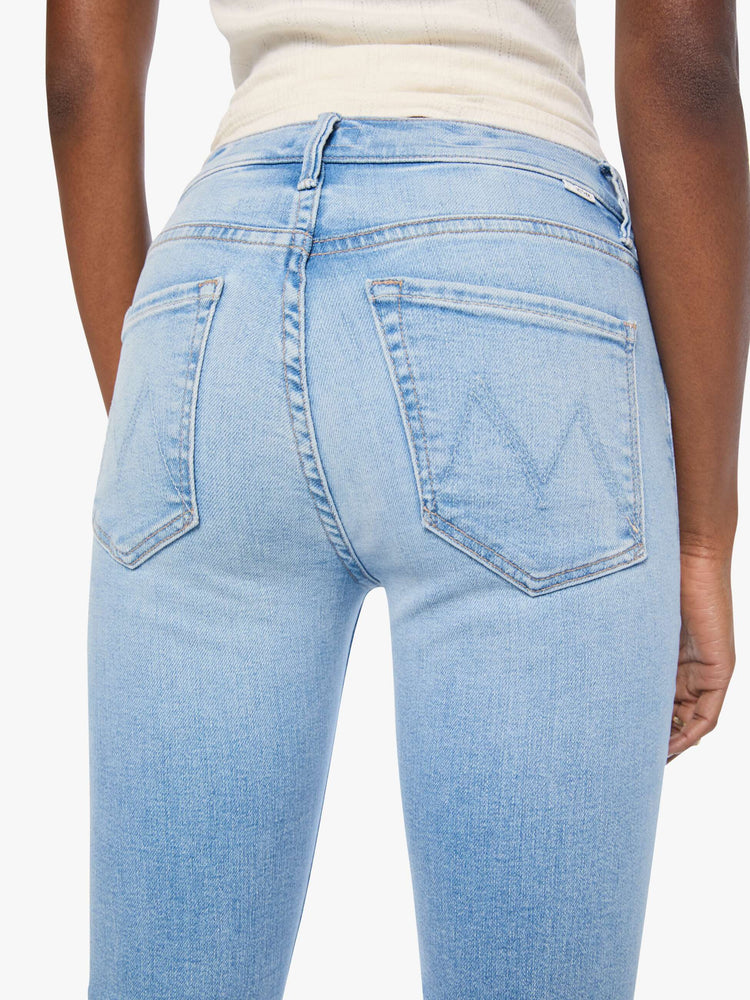 Close up view of a woman in light blue mid-rise jean has a straight leg, zip fly, 29-inch inseam and a clean hem.