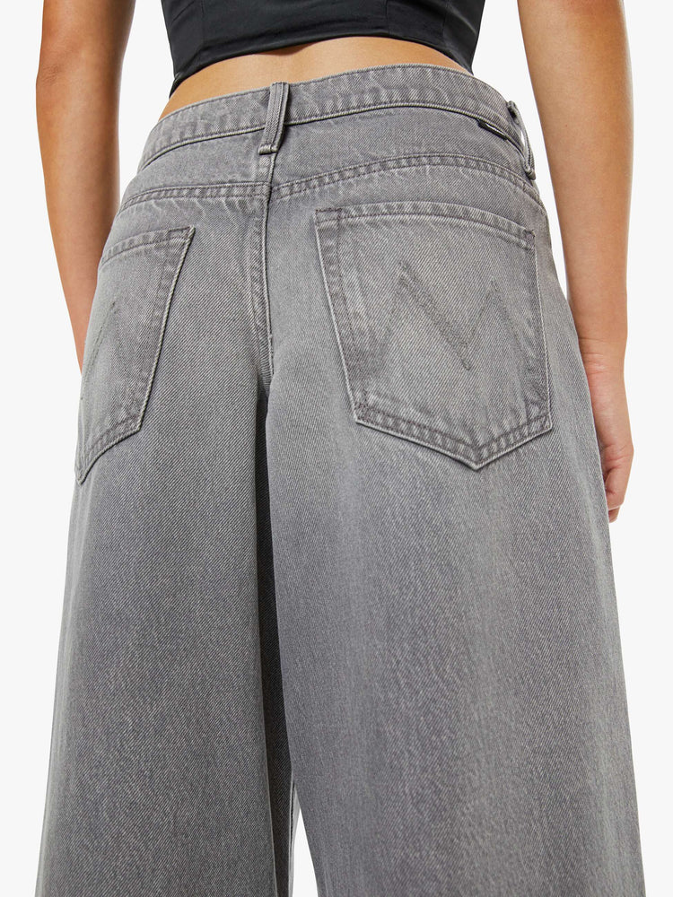 Back view of a woman in a grey super high-waisted jeans have a low-slung fit, zip fly, loose wide-leg and a long 32-inch inseam with a clean hem.