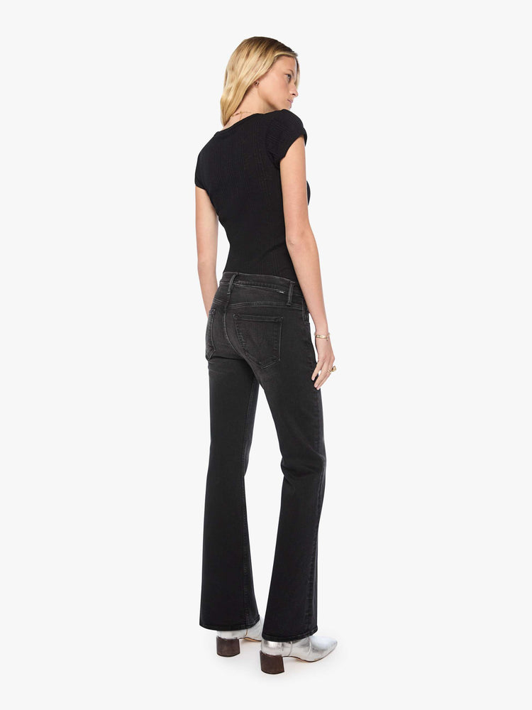 Back view of a woman in mid-rise bootcut jean with a long 32-inch inseam and a clean hem.