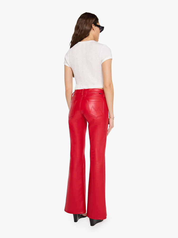Back view of a woman in a cherry red lower-rise bootcut pant with a long 32-inch inseam and a clean hem.