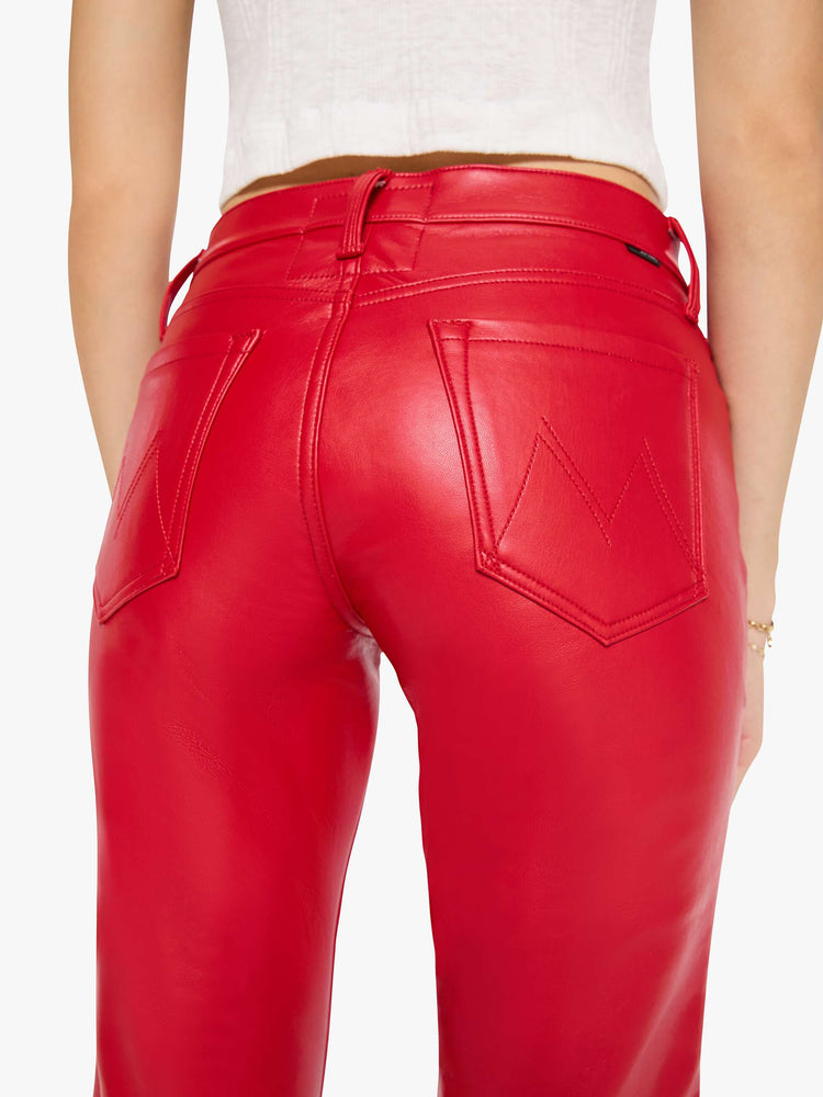 Close up view of a woman in a cherry red lower-rise bootcut pant with a long 32-inch inseam and a clean hem.