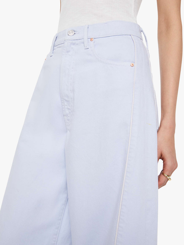 Close up view of a woman in a washed light blue super high-waisted barrel-leg jeans with a long 32-inch inseam, zip fly, clean hem and relaxed fit.