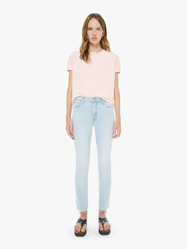 Front view of a woman in a light blue high-rise straight leg with a zip fly, 27 inch inseam and a frayed hem.