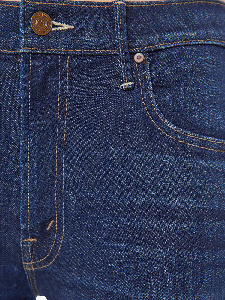 Swatch view of a woman in a dark blue high-waisted bootcut is cropped at the ankle with a frayed step-hem.