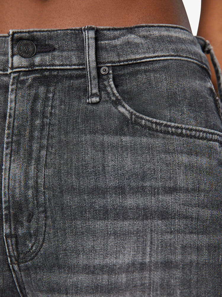Swatch view of a woman high-waisted bootcut is cropped at the ankle with a frayed step-hem in a faded black wash.