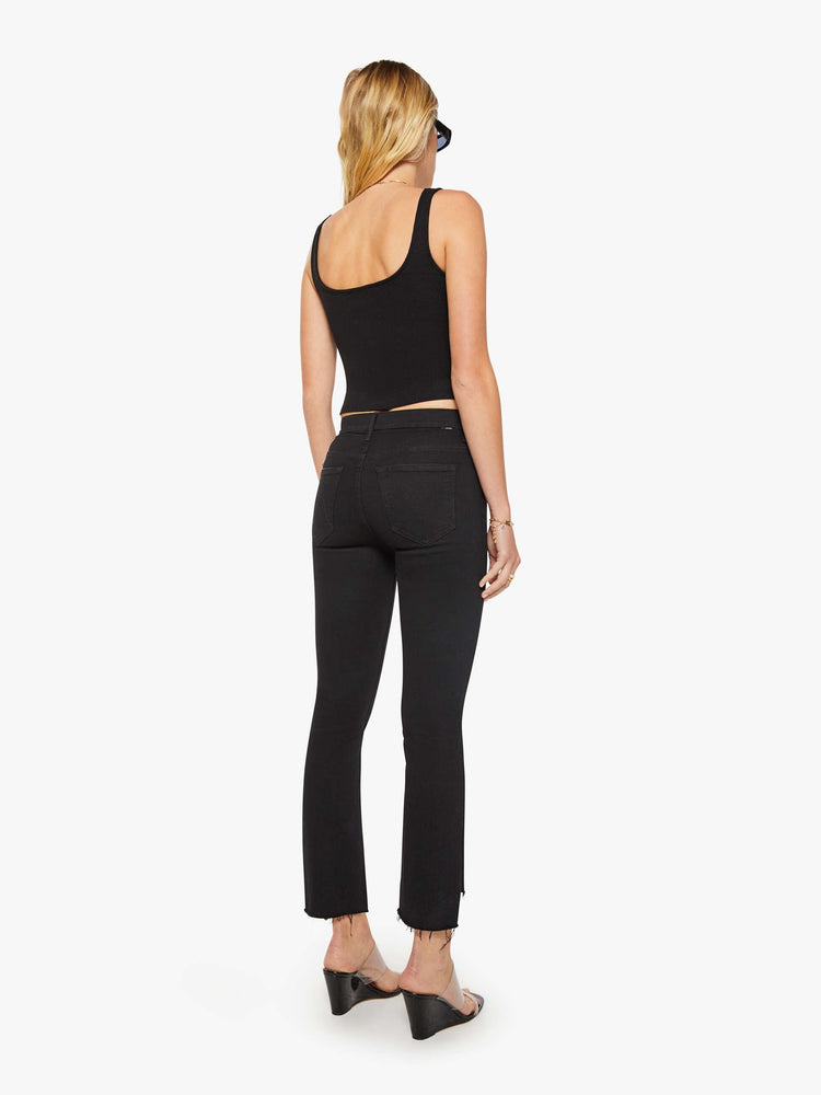 Back view of women’s black cropped bootcut jean with a step frayed hem.