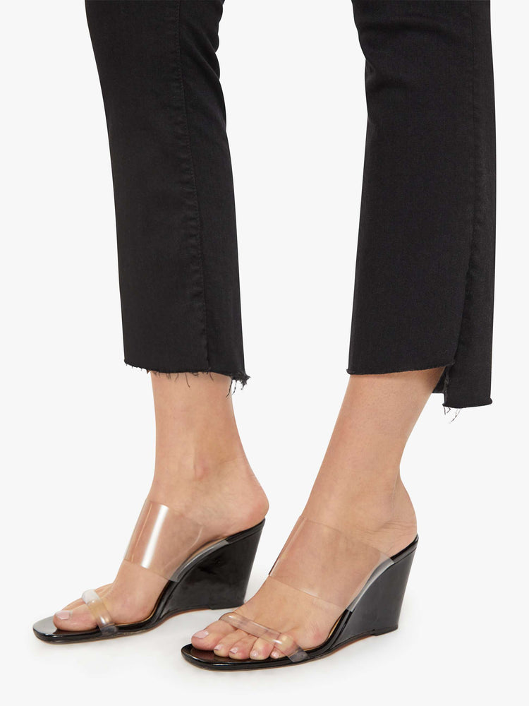 Hem close up view of women’s black cropped bootcut jean with a step frayed hem.