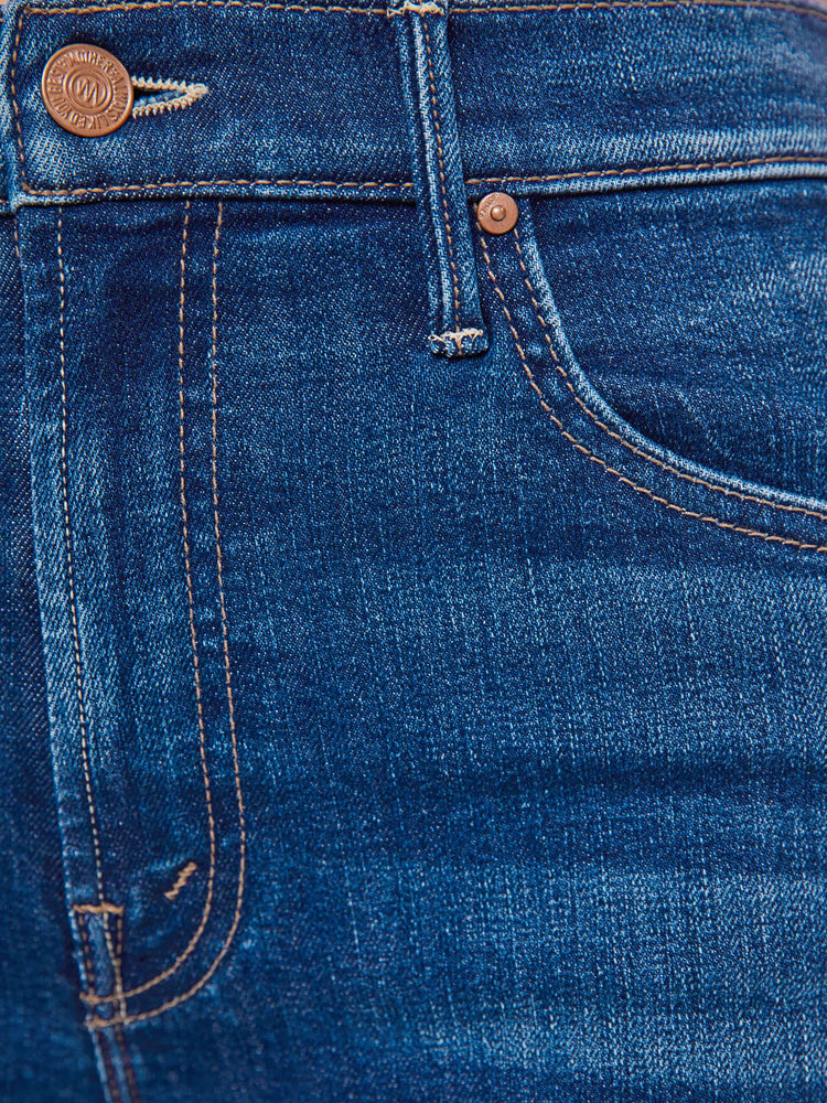 Swatch view of a woman in a high-waisted bootcut has a zip fly, ankle-length inseam and a frayed step-hem.