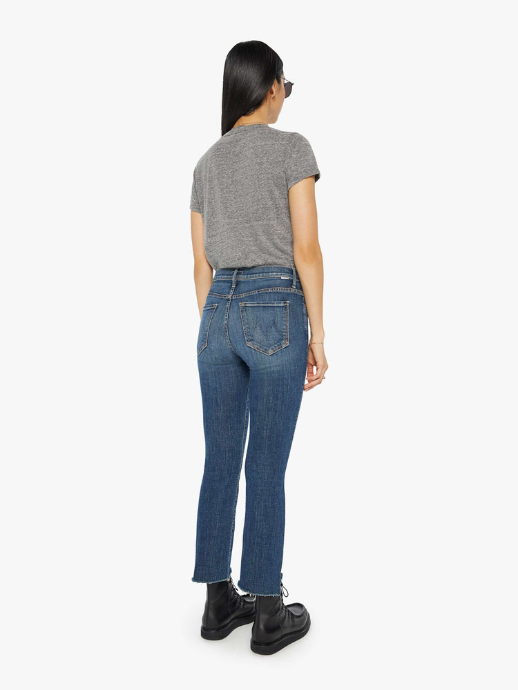 Back view of women’s medium blue cropped bootcut with step frayed hem