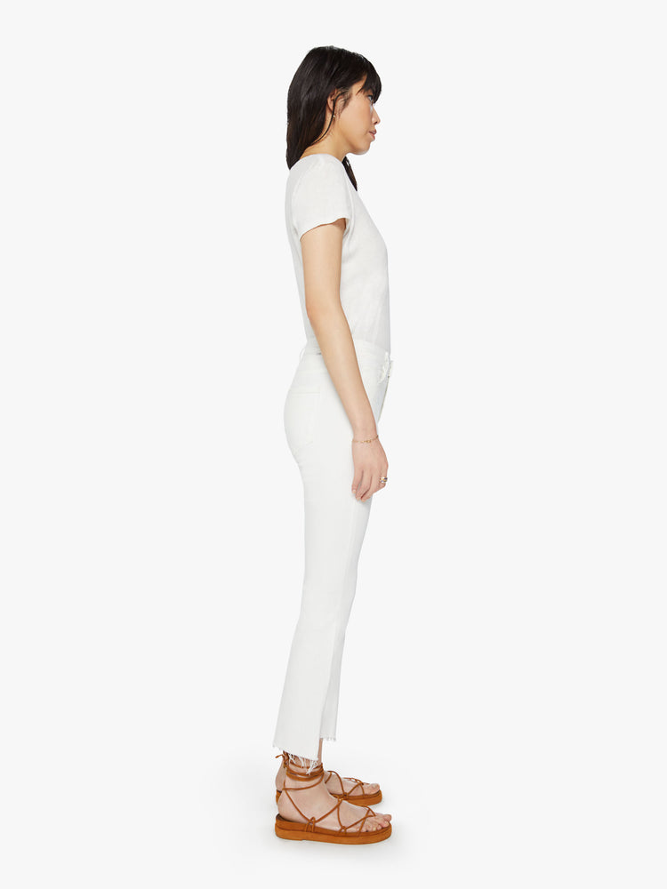 Side view of women’s white cropped bootcut with step frayed hem.