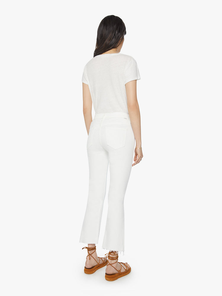 Back view of women’s white cropped bootcut with step frayed hem.