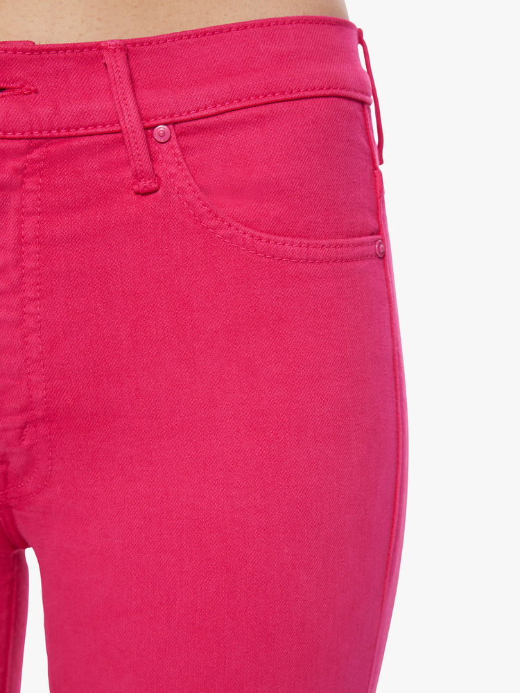 Swatch view of a woman high-waisted bootcut hits at the ankle with a frayed step-hem in a hot pink hue.