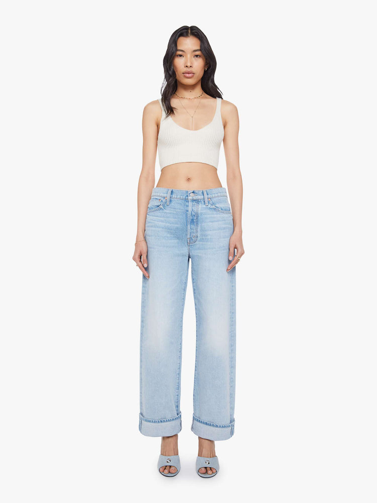 Front view of a woman in a light blue jean designed to sit on the hips with a slouchy fit, loose straight leg, button fly and a 29-inch inseam with a clean, untacked cuffed hem.