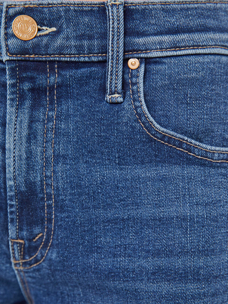 Swatch view of a woman in a med blue mid-rise straight-leg jeans with a zip fly, ankle-length inseam and a frayed hem.